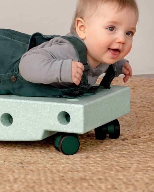 Child riding a MODU build with Swirly Wheels — creative indoor play