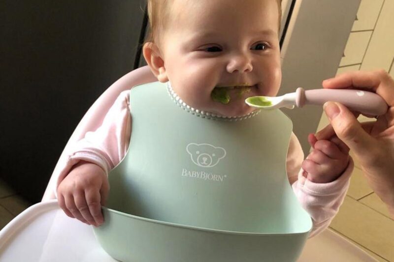 BabyBjörn śliniaczek &mdash; miękki, regulowany pałąk na szyję, dziecko karmione łyżeczką