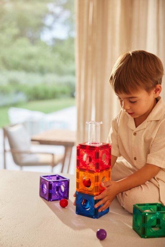 Child playing with Cleverclixx Ball Run Compact Pack Intense — magnetic ball run in bold colours