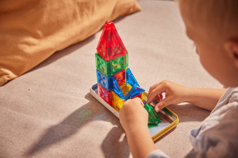 Dítě si hraje s mini magnetickými kostkami Cleverclixx Mini Tiles Pack Intense v kovové krabičce